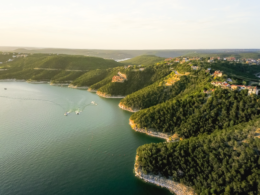 aerial of trees and cliffs at lake travis in austin texas