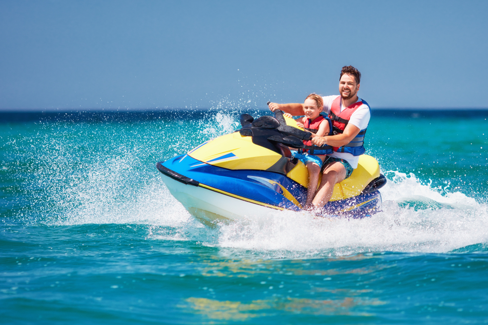 a man and a kid on a jet ski in water
