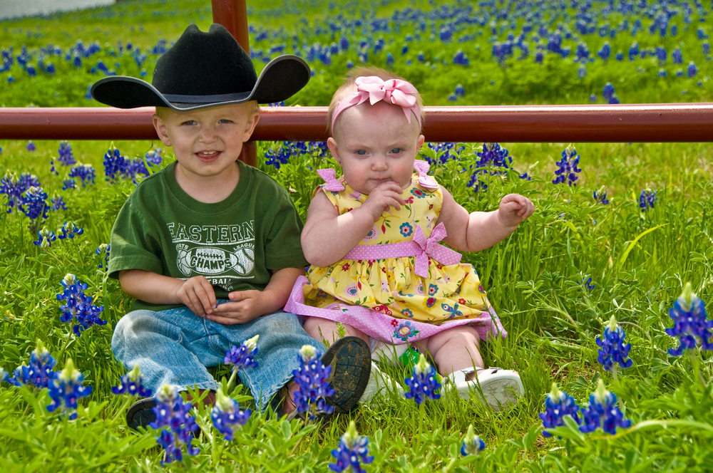 kids sitting in a bluebonnet field one of the best things to do in texas with kids 
