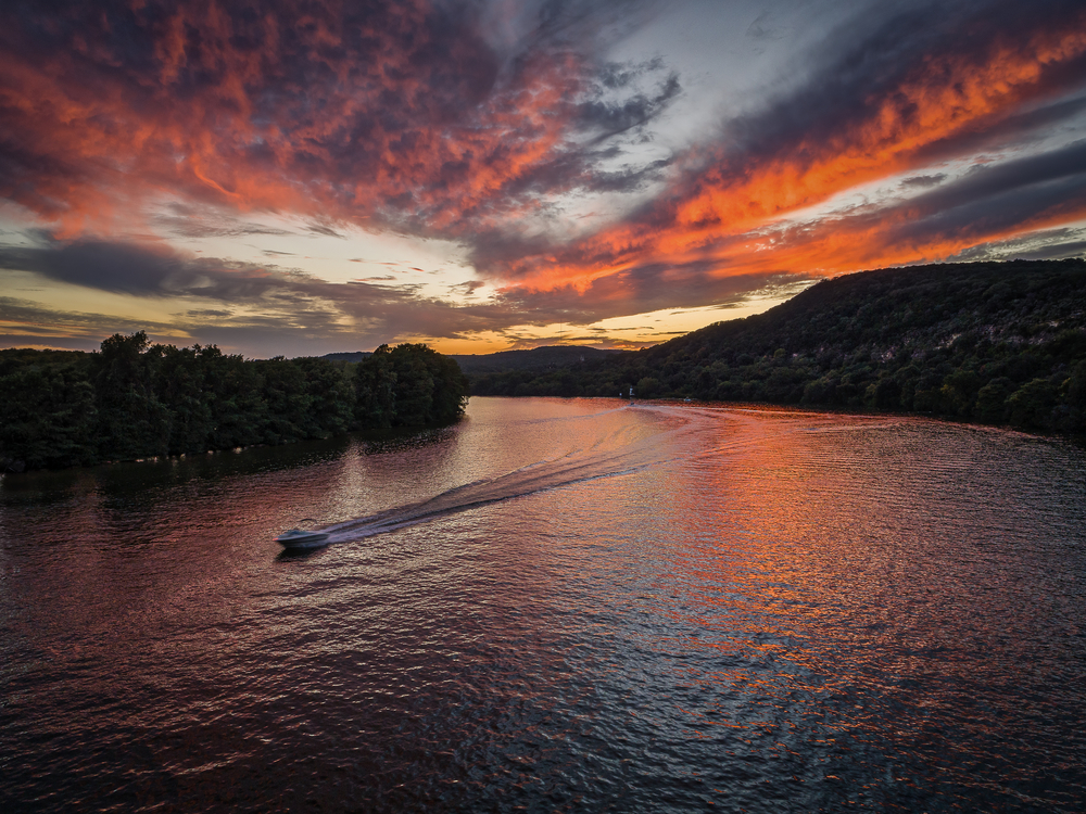 Boat moving in a lake during sunset best tours in austin
