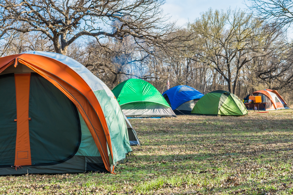 tent pitched together surrounded by trees camping in texas