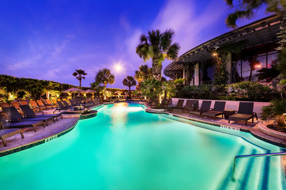 Swimming pool wrapped around a hotel with palm trees