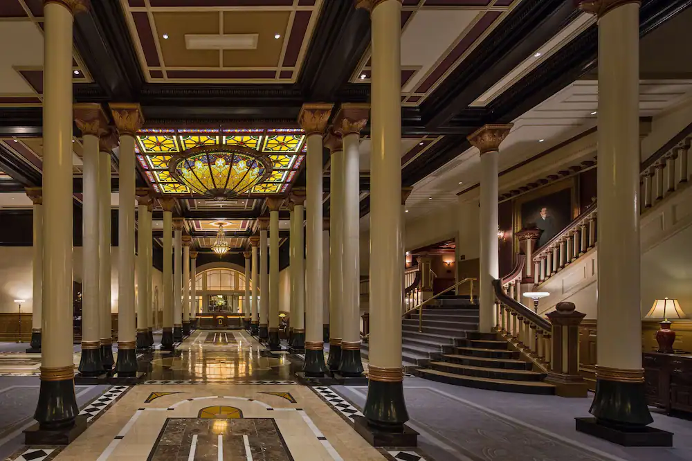 the white and brown ornate lobby of The Driskill with a glass ornate ceiling