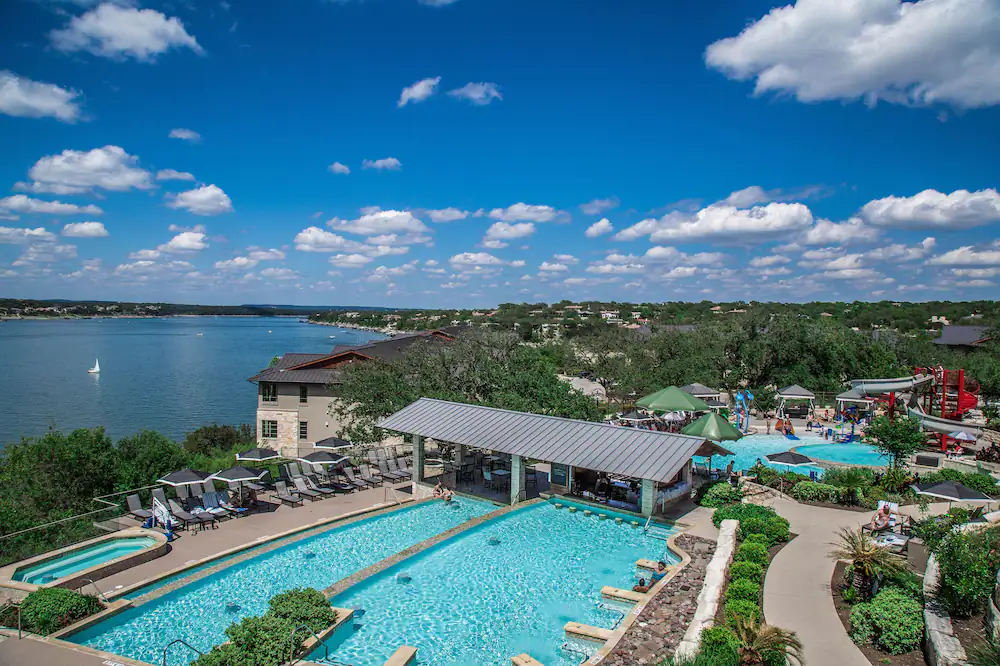 An erial view of a hotel resort with two pools and a water slide