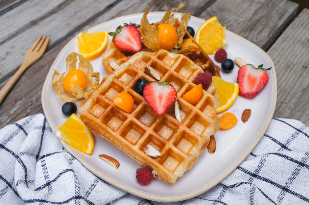 Waffles with fresh fruit and caramel on white plate best breakfast in houston
