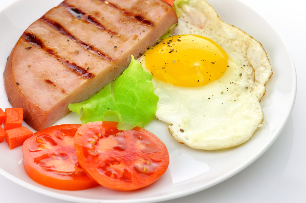 Sliced grilled ham with eggs and vegetables