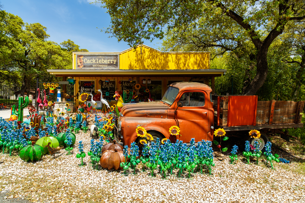 orange truck surrounded by wildflowers in front of a shop romantic getaways in texas