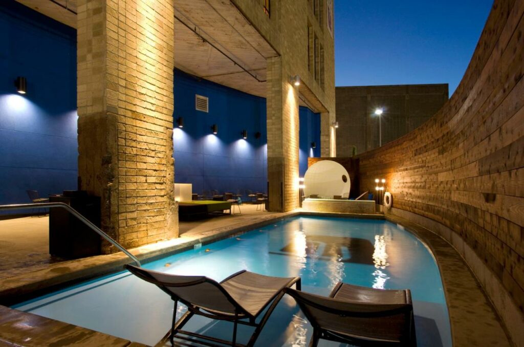 outdoor swimming pool surrounded by seating area best boutique hotels in dallas