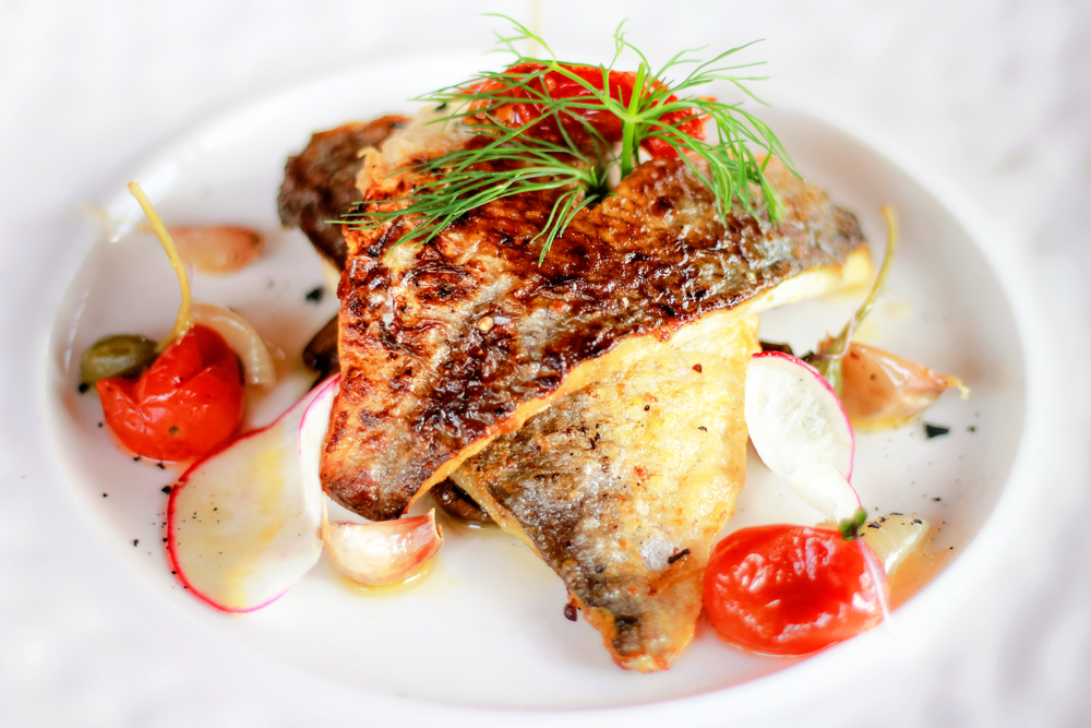 grilled fish with butter capers, tomatoes and lemon on a plate best restaurants in south padre island
