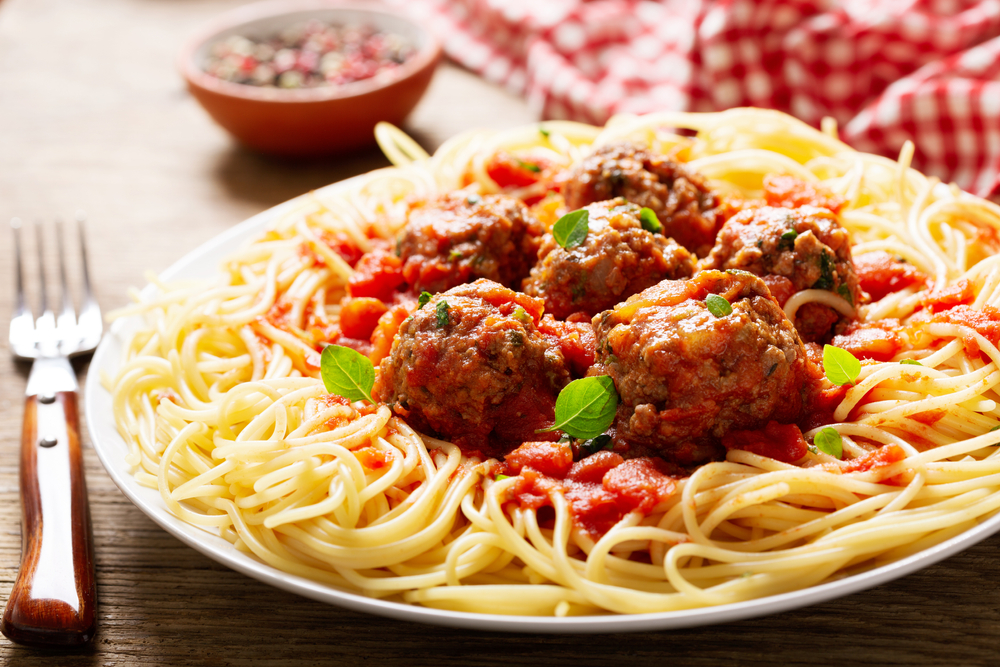 a plate of pasta with meatballs on a wooden table best restaurants in south padre island
