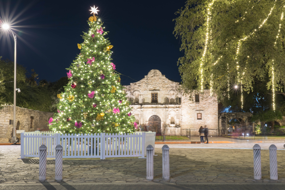 A picture of a large Christmas tree covered in lights and ornaments in front of the Alamo in San Antonio, Texas.
