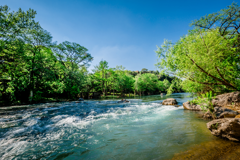 Rushing rapids at Guadalupe River on a sunny day.