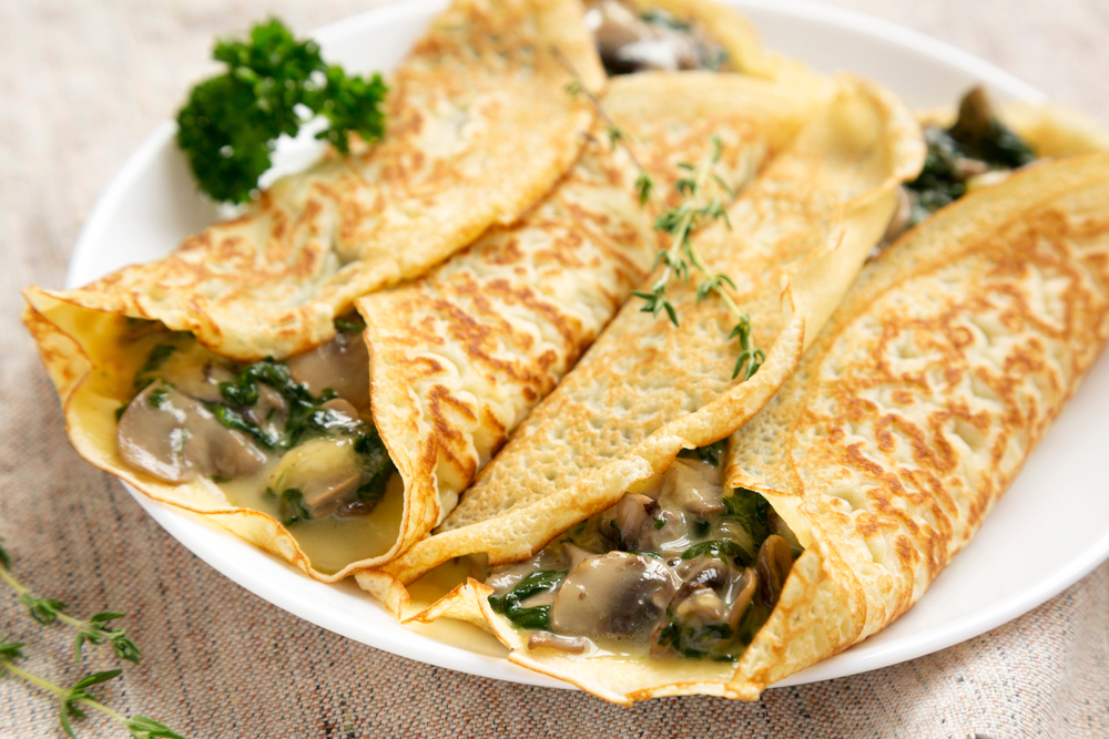 A savory mushroom crepe garnished with thyme leaves. Crepeccino, one of the restaurants in San Antonio, has tasty crepes like this one