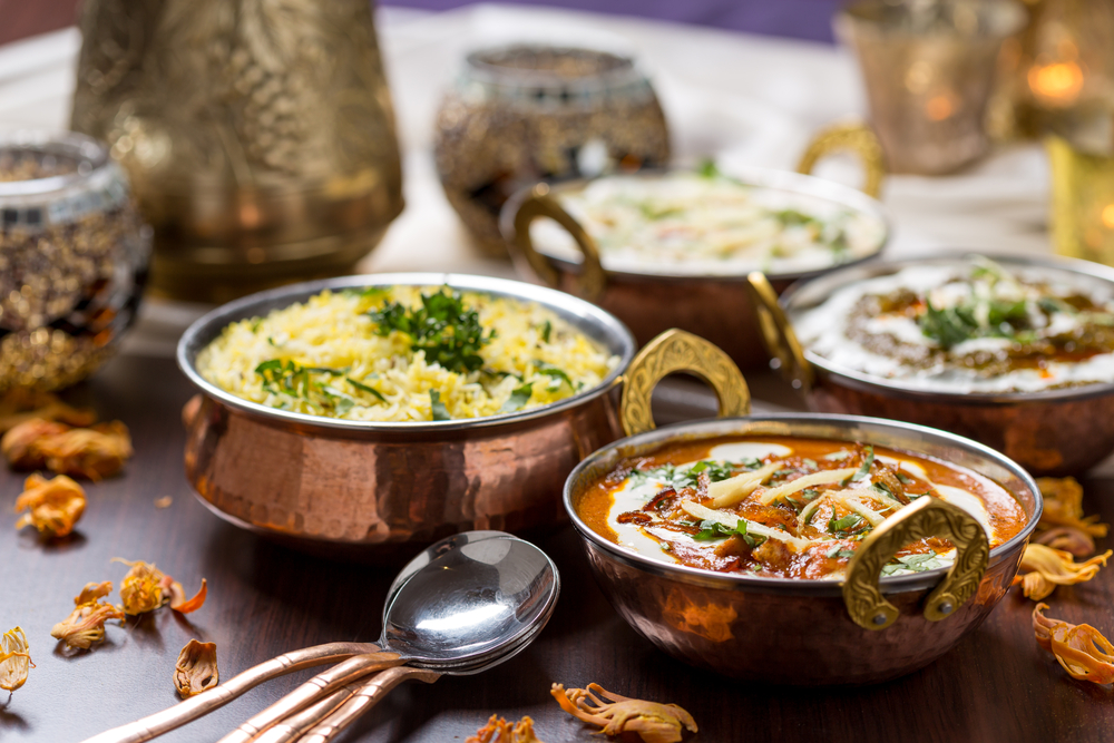 Four copper bowls filled with delicious Indian food. Find this at Tarka Indian Kitchen