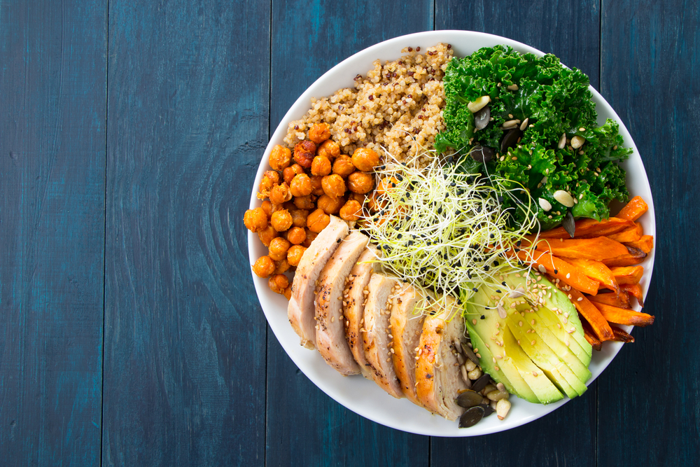 A Buddha bowl with ingredients like chickpeas, kale, carrots, and quinoa