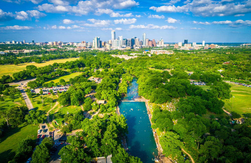 above view of Barton Springs Municipal Pool with downtown austin in the background