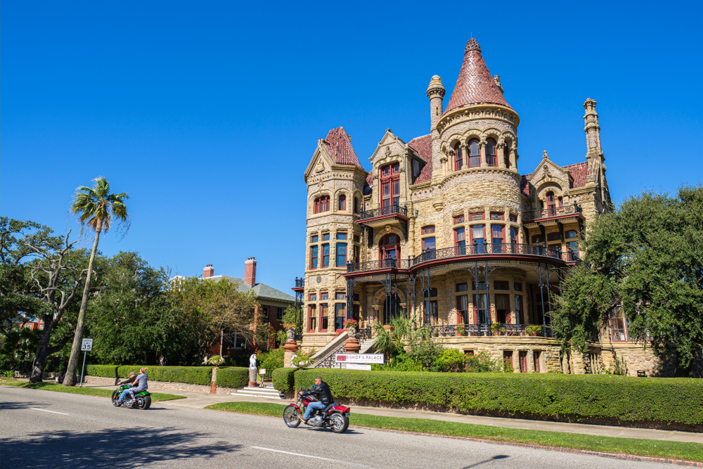 Bishop's Palace on a sunny day with people riding motorcycles in front on their texas road trip