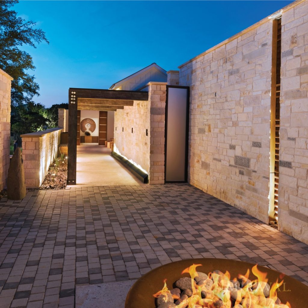 A nicely lit stone outdoor corridor at night 