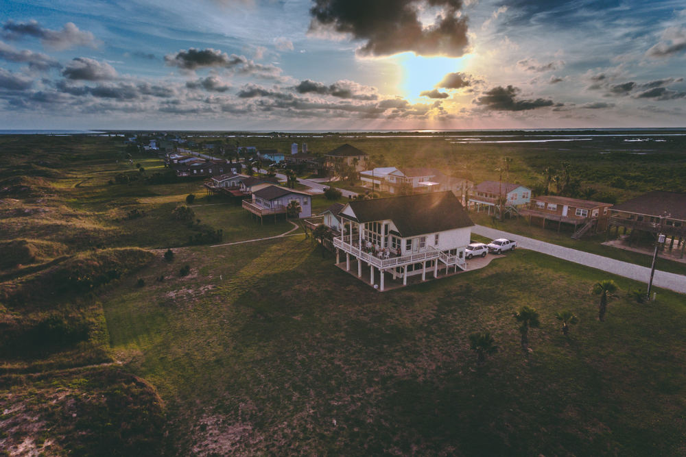 A white house surrounded by other houses in a beach town in Texas