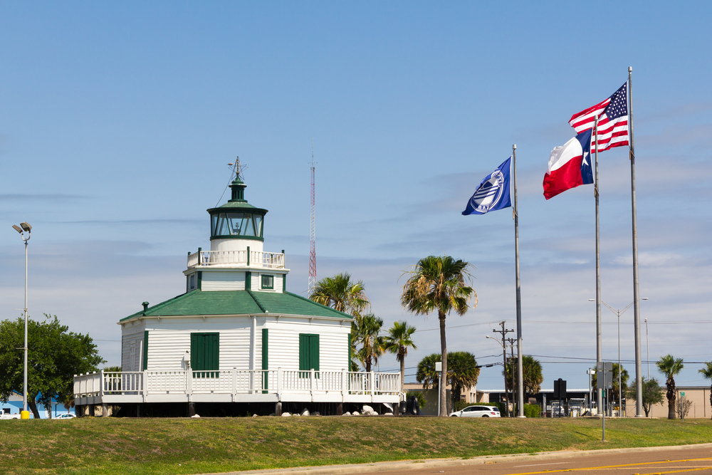 Port Lavaca Lighthouse a green and white building with 3 flags flying on a sunny day