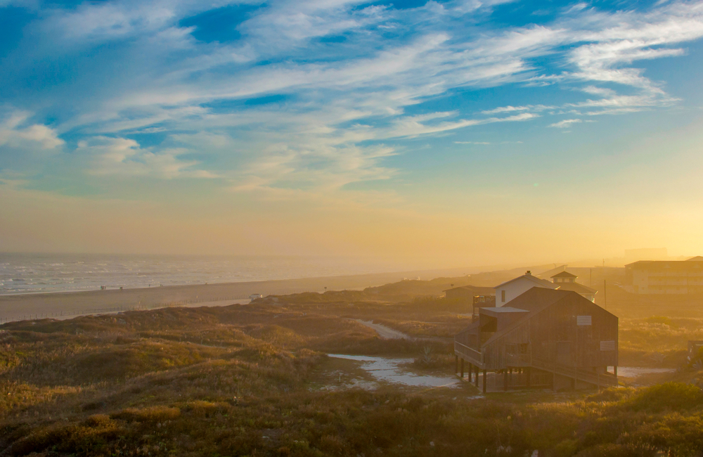 House in the sun and mist on a beach at sunset