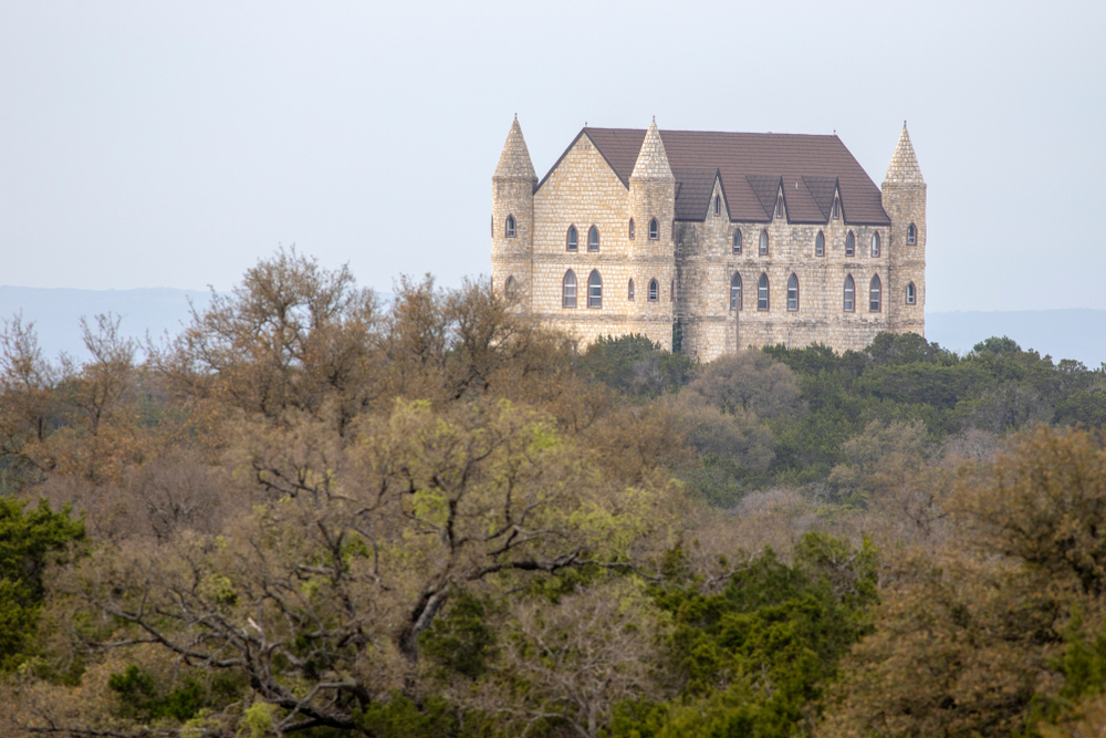 Castle Falkenstein, one of the castles in Texas you must see, surrounded by trees.