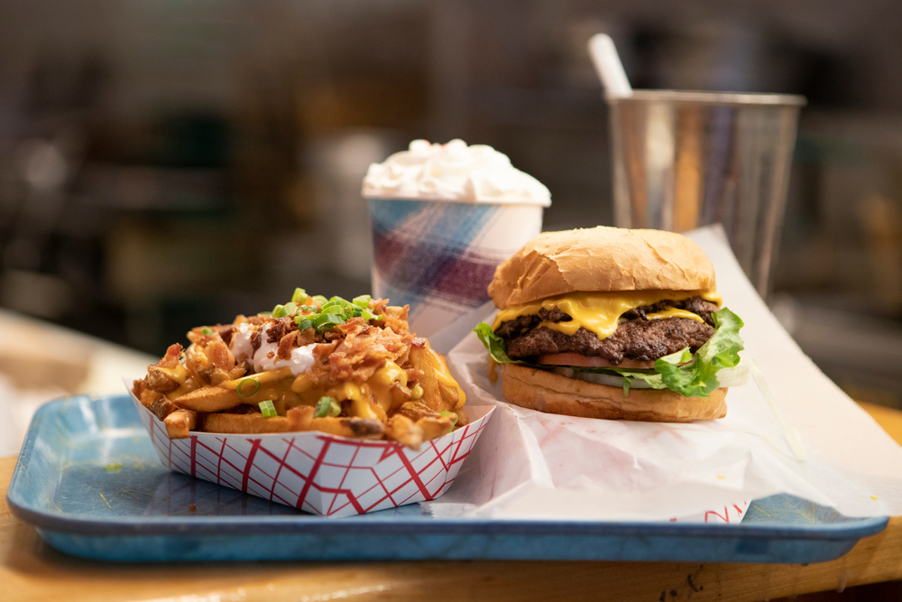 A blue diner tray that has a basket of chili cheese fries, a cheeseburger, and a milkshake. You can find something like it at restaurants in Amarillo. 