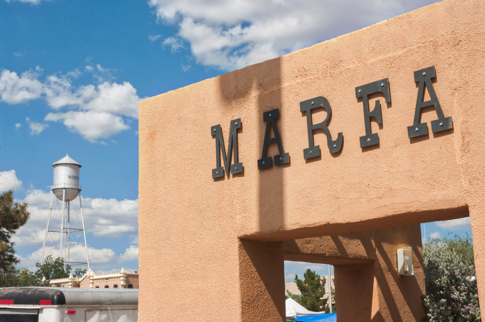 Marfa sign on pink wall with water tower in the background