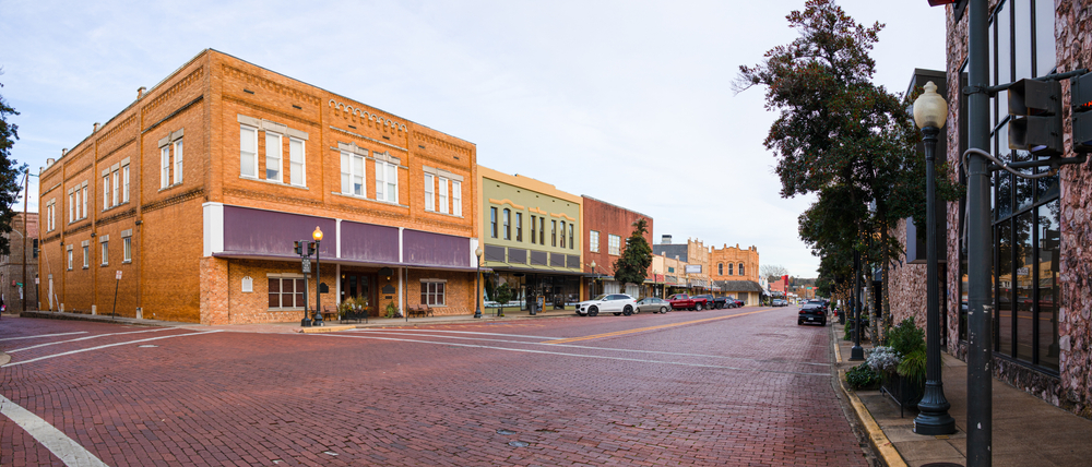 View of downtown Nacogdoches, brick streets and historic store fronts on a main street.