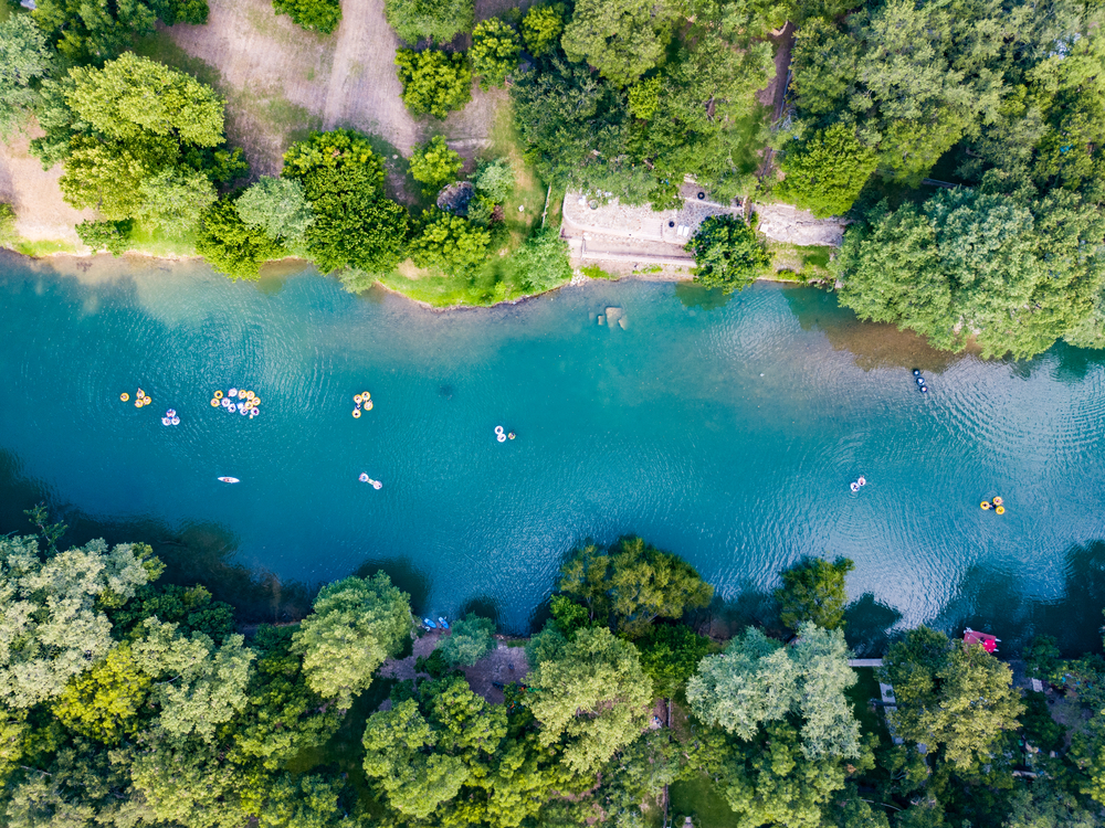 An aerial shot of people tubing on the Guadalupe River,  one of the most fun things to do in Canyon Lake, TX.