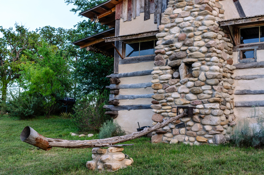 An old styled home with a cobblestone chimney 