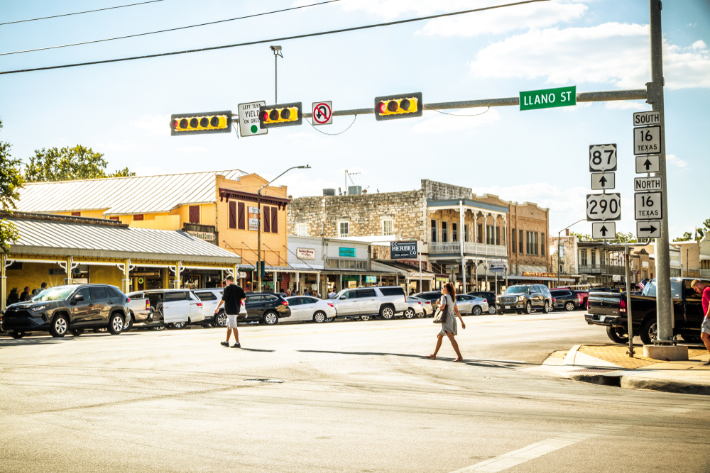 People crossing Main Street on a sunny day one of the best places to visit in Fredericksburg Texas