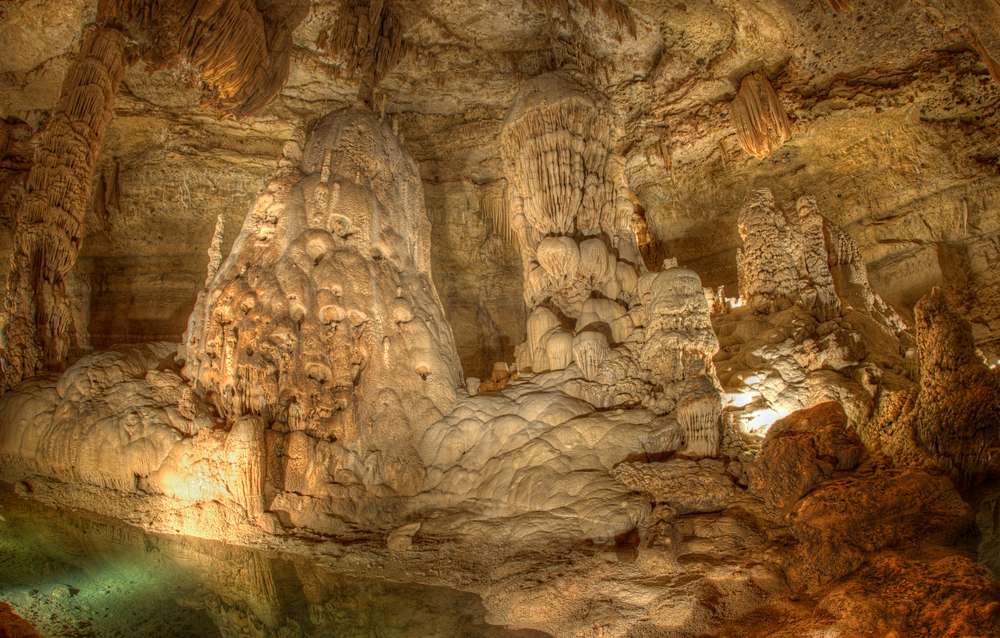 an underground rock cavern with a small pool of water