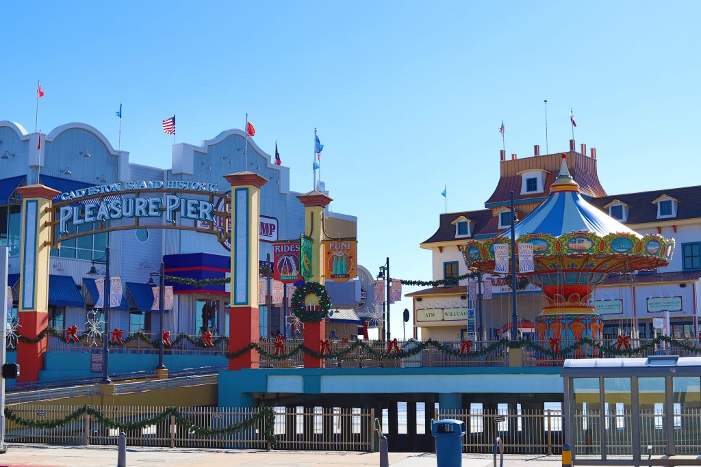 Amusement parks in Texas that are located on the Pleasure Pier with cartoonish buildings and bright colors.