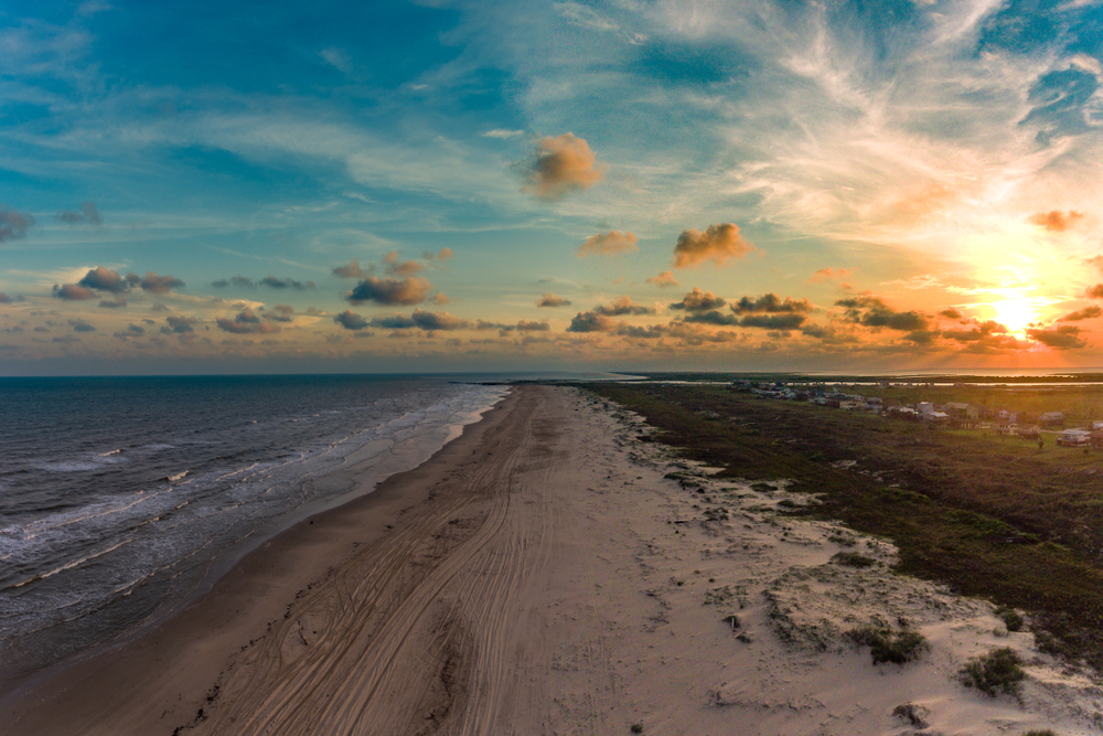 an aerial view of a Texas beach at sunset 