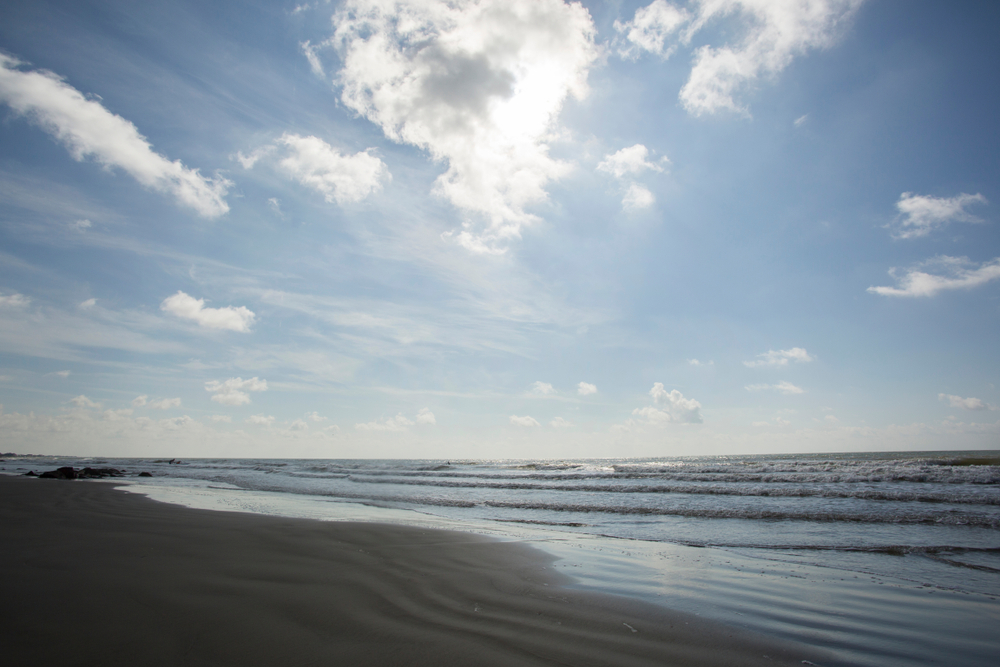 waves settling on a sandy shore on a sunny day at a texas beach