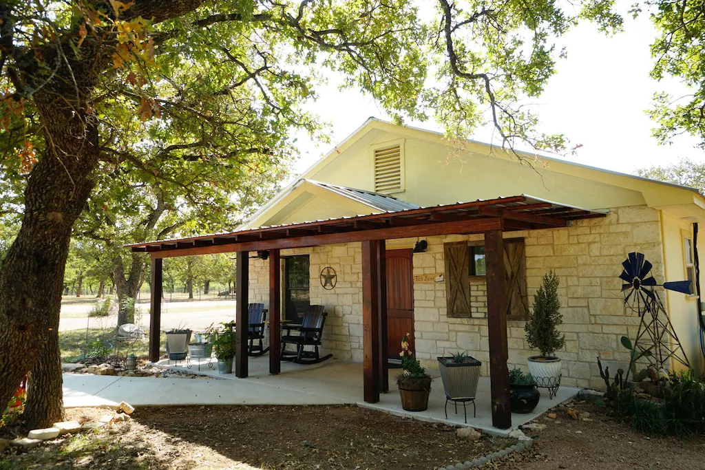 Front of the Bakery Haus, a stone and wood cabin with patio furniture, one of the best cabins in Fredericksburg, TX.