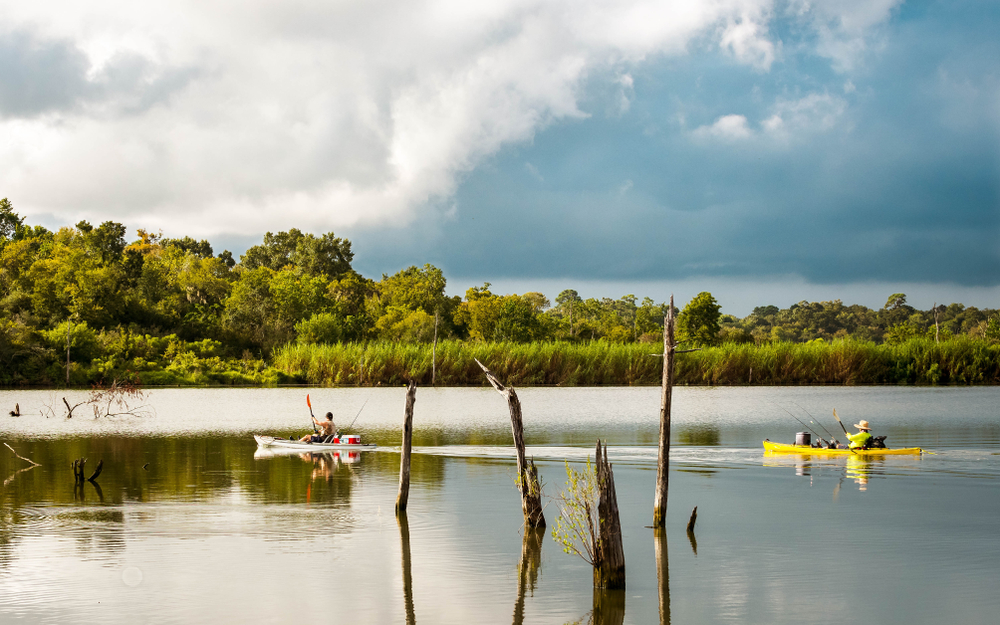 Two visitors fishing on the Armand Bayou while kayaking in Texas