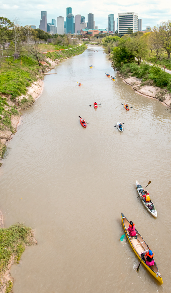 The Houston skyline in the background with kayakers on the Buffalo Bayou. This bayou provides great kayaking in Texas!