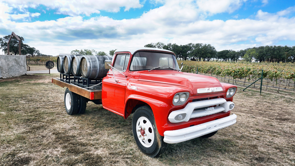 Red trucking with wine barrels in the back sitting at a wineries in Fredericksburg