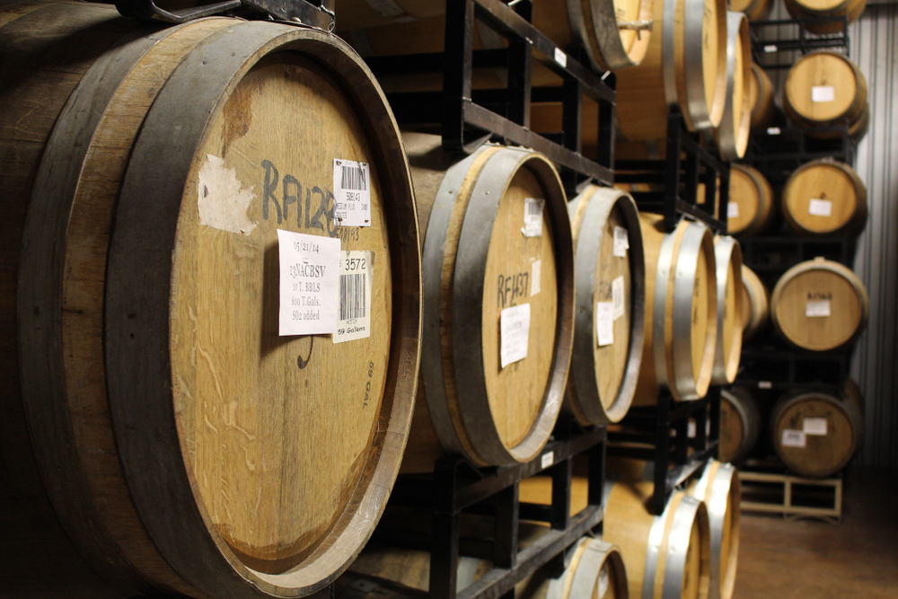 Multiple rows of wine barrels stacked on top of each other at wineries in Fredericksburg