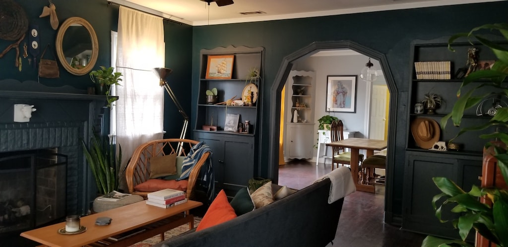 This photo shows the living and formal dining rooms of the Artist Ranchette. The walls are painted a deep salamander green. There are charming built ins full of art and quirky antiques. This is one of the best vacation rentals in Texas. 