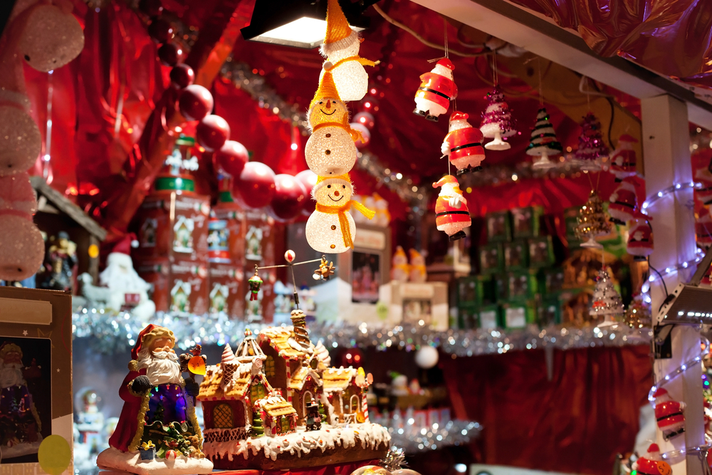 Different trinkets in a Christmas themed shop. You can see snowmen, Santa's, Christmas villages, and more. 