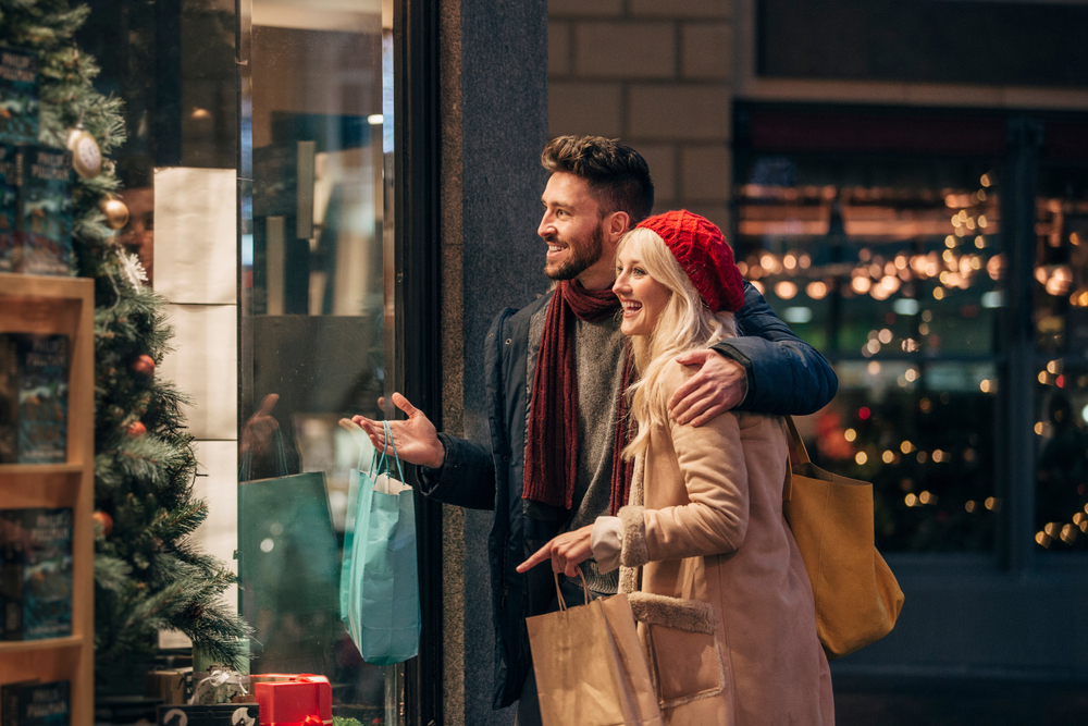 A couple window shop during the Christmas season