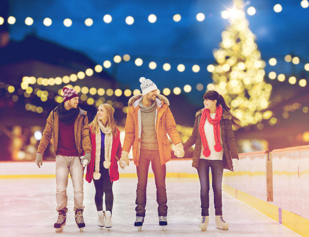 Friends go ice skating outdoors during the winter