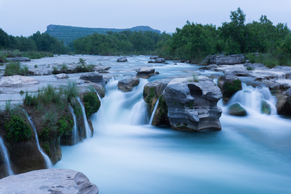 A beautiful waterfall flowing through rocks in a lush green landscape