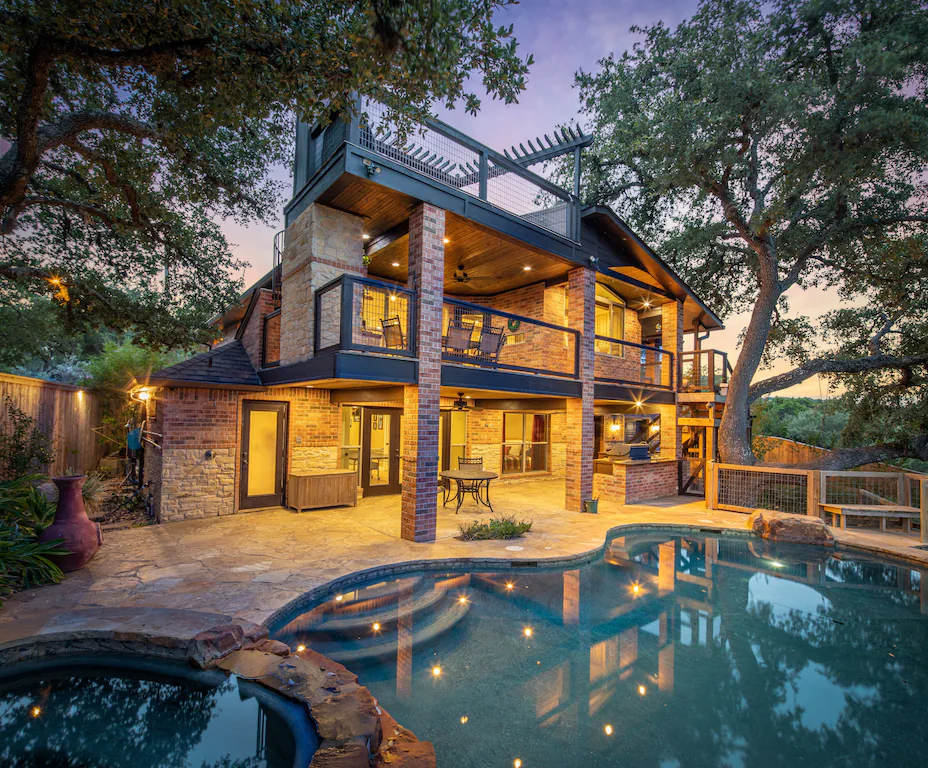 2 story cabin pool side with large trees over looking canyon lake