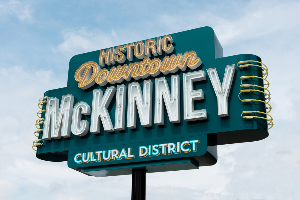 green sign with yellow and white lettering that says historic downtown McKinney cultural district 