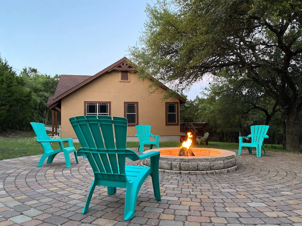 Four chairs sitting around a fire pit in front of a cabin on Canyon Lake 