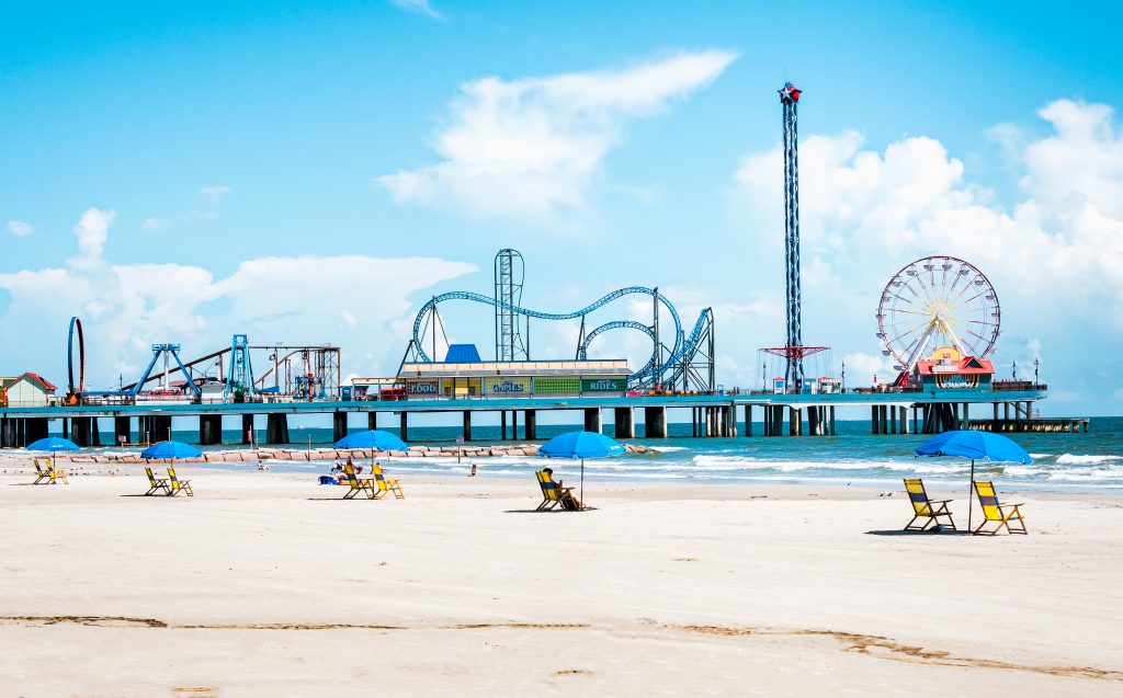 View of Galveston's pier and all of the amusement rides next to the beach.